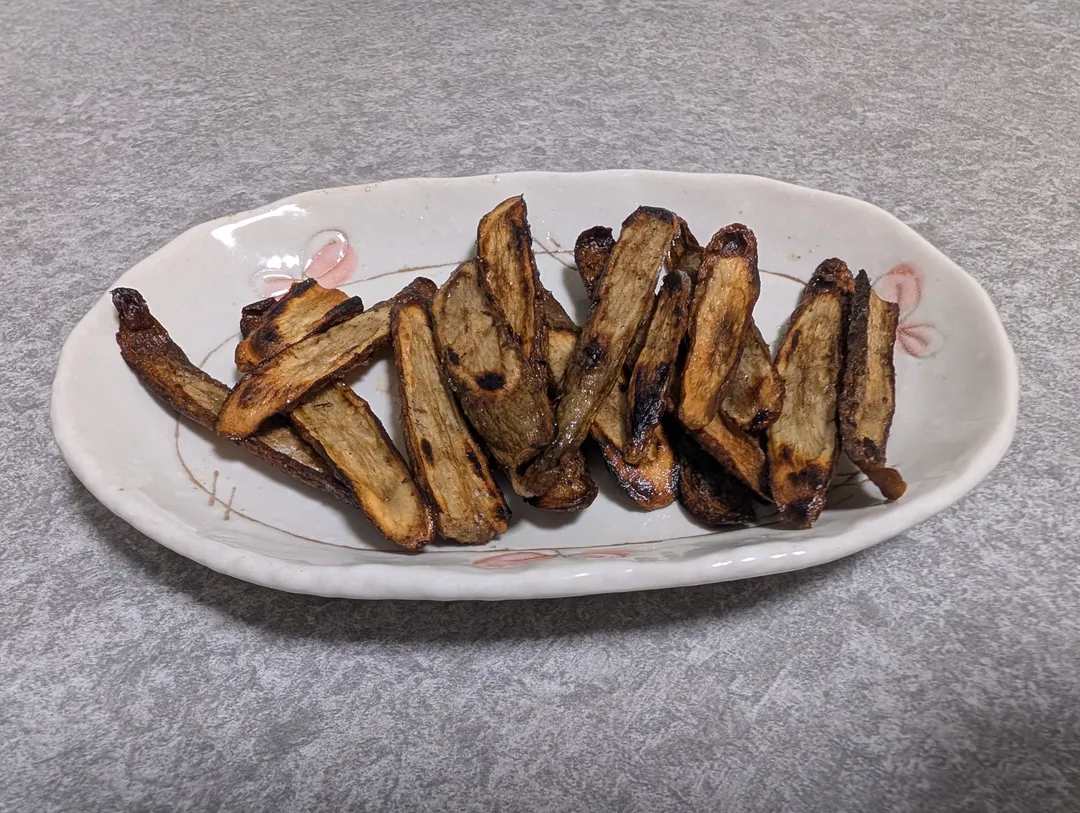 焼き上がった焦がしごぼうを楕円の皿に盛ったところ
